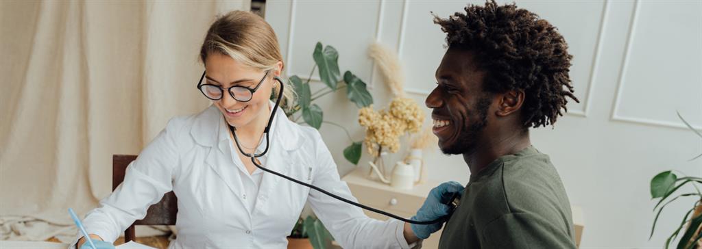 Healthcare worker with stethoscope listening to patient's chest